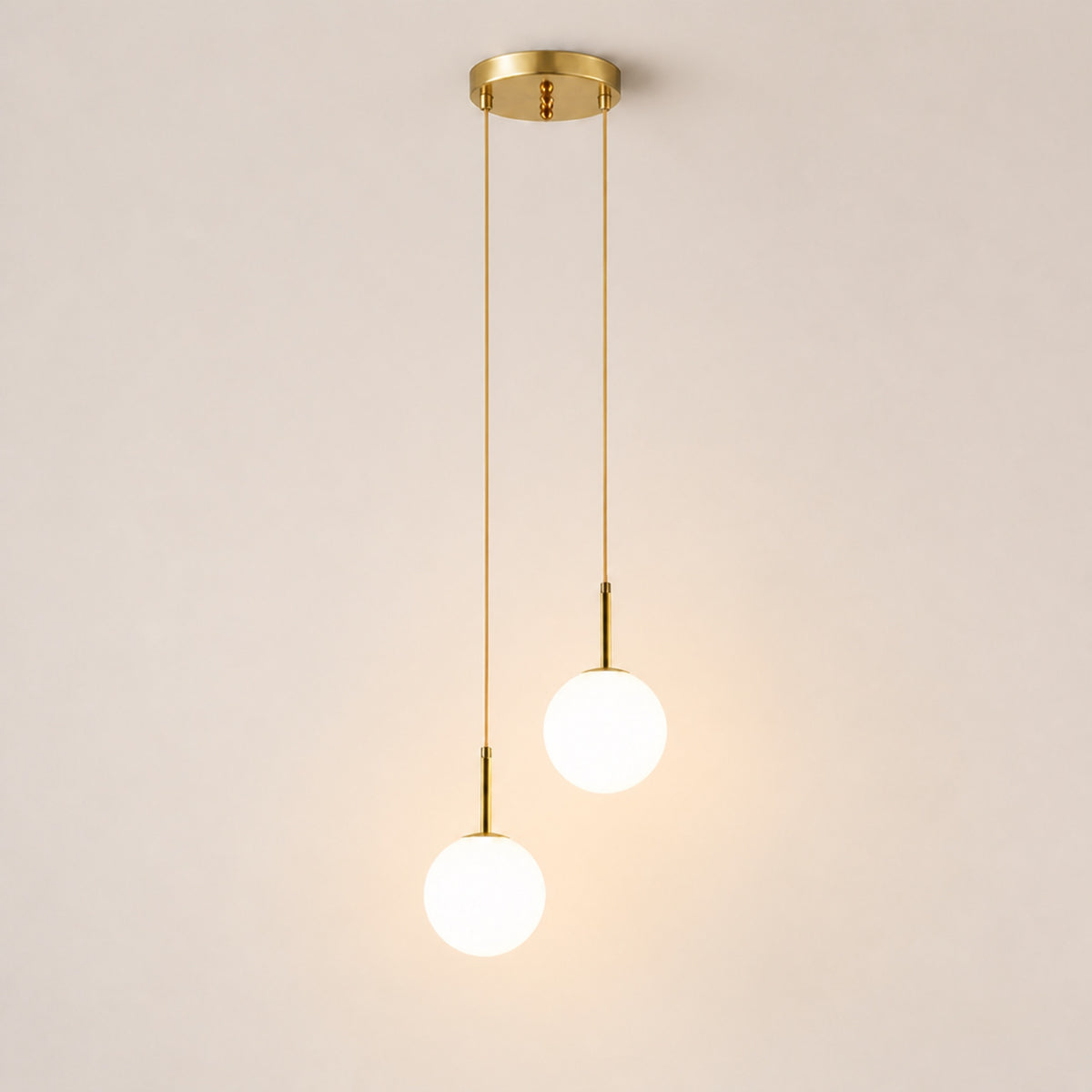 Suspension globes opale sur câbles laiton, sur fond neutre
